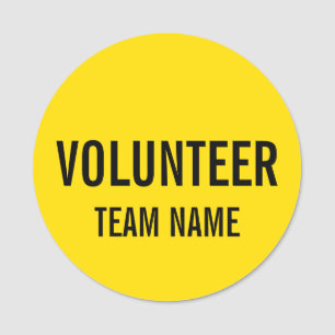 Gele vrijwilligersbadge met de naam van het team v naamplaatje