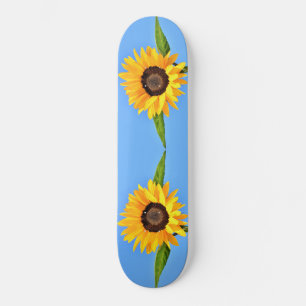 Gele zonnebloemen tegen zon op blauwe hemel - zome skateboard