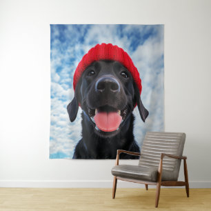 Gelukkige Labrador in een rode muts onder een blau Wandkleed
