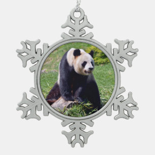 Giant panda zit op een steen tin sneeuwvlok ornament