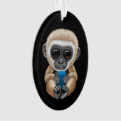 Gibbon mignon de bébé tenant un noir de téléphone (devant)