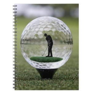 Glazen golfbal met golfspeler binnen, notitieboek