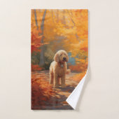 Goldendoodle dans les feuilles d'automne qui tombe (Serviette à main)