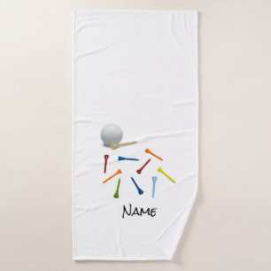Golfbal en kleurrijke t - shirts op een witte badh badhanddoek