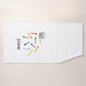 Golfbal en kleurrijke t - shirts op een witte badh badhanddoek (Badhanddoek)
