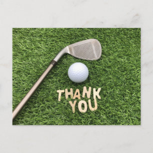 Golfbal met bedankt woord op groen gras briefkaart