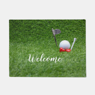 Golfbal met twee rode harten op groen gras deurmat