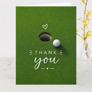Golfbal naast hole op groen gras Bedankt Kaart