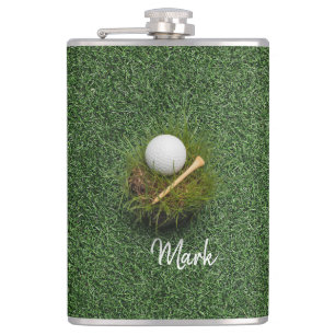 Golfbal op groen gras heupfles
