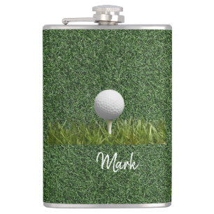 Golfbal op groen gras heupfles