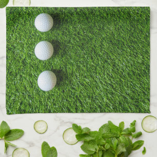 Golfballen liggen op groen gras theedoek