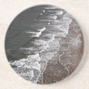 Golven breken op een zandig strand zandsteen onderzetter