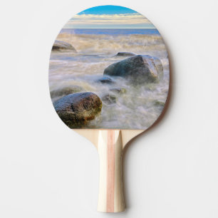 Golven slaan tegen rotsen aan de kust tafeltennisbatje