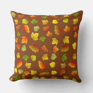 Gouden, groene, oranje herfstbladeren op bruin kussen