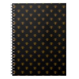 Gouden metalen folie bijen op zwart notitieboek