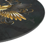 Gouden vogel schedel op zwarte achtergrond snijplank (Hoek)