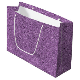 Grand Sac Cadeau Un sac-cadeau pailleté violet avec une poignée bla