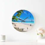 Grande Horloge Ronde Belle plage tropicale ensoleillée Photo<br><div class="desc">Une horloge avec une belle photo. Une plage de sable blanc à l'eau bleue azur. Image relaxante avec un ciel ensoleillé et un surf doux en mousse avec quelques mignons feuilles tropicaux encadrant l'image.</div>