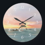 Grande Horloge Ronde Couleur d'eau de la mer des Dolphins Beach Sunset<br><div class="desc">L'art du mur d'horloge à thème de la plage présente un tableau d'aquarelle représentant un cordon de dauphins qui s'enfonce et nage au coucher du soleil sur l'océan. Parfait pour les thèmes de la maison de plage, de la mer, du littoral et de la décoration tropicale. Oeuvre de KL Stock....</div>