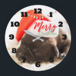 Grande Horloge Ronde Cute Puppy Pug in a Red Santa Hat Christmas<br><div class="desc">A clock with an adorable photo of a pug puppy sleeping while wearing a red santa hat. Merry Christmas is written on the band of his hat,  in a trendy handwritten font,  in the festive colors red and green. Christmas lights strung across the top creates additional seasonal holiday flair.</div>