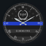 Grande Horloge Ronde Police Styled American Flag Badge and Name<br><div class="desc">A wall clock featuring a thin blue line American flag symbolic of law-enforcement.  Roman numerals and a spot for yours or your gift recipient's badge number and last name.</div>