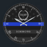 Grande Horloge Ronde Police Styled American Flag Badge and Name<br><div class="desc">A wall clock featuring a thin blue line American flag symbolic of law-enforcement.  Roman numerals and a spot for yours or your gift recipient's badge number and last name.</div>