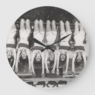 Grande Horloge Ronde Showgirls sur les bars à singes, design ludique.