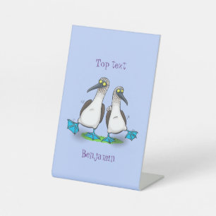 Grappig, gelukkig blauw gefundeerde cartoon die op reclamebord met voetstuk