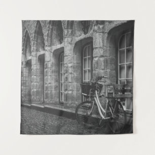 GRAYSCALE FOTO VAN BIKE PARKED BESIDE BOUW WANDKLEED
