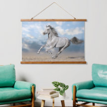 Grijs Arabisch paard galoppeert door zandlandschap