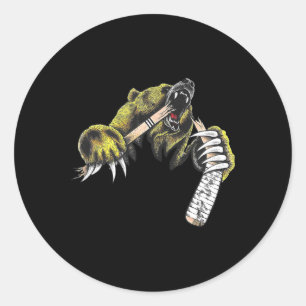 Grijze beer die door een bijtende hockeystick bree ronde sticker