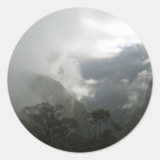 Grijze mistige wolken boven de bergen ronde sticker