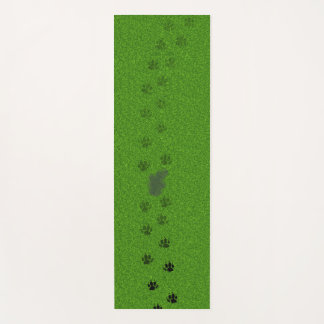 Groen gras met hondenpootafdrukken en een plas uri yogamat