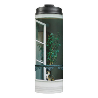 GROEN PLANT OP WITTE VENSTER THERMOSBEKER