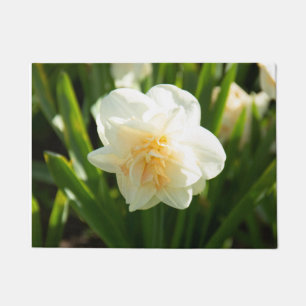 Grote witte narcissen op een lentedag deurmat