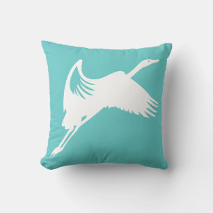 grue blanche sur coussin bleu turquoise