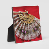 Hand Held Fan op een rode achtergrond Fotoplaat (Voorkant)