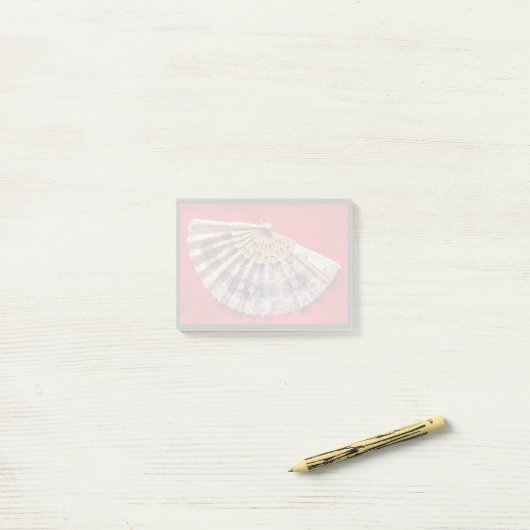 Hand Held Fan op een rode achtergrond Post-it® Notes (Op bureau)