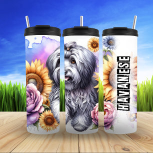 Havanezer in zonovergoten bloemen thermosbeker