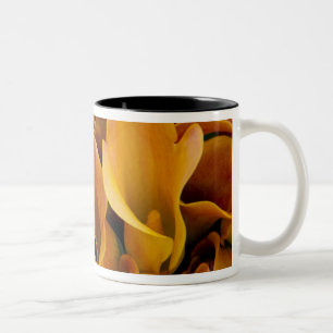 Helder gekleurde calla's bij de tweekleurige koffiemok