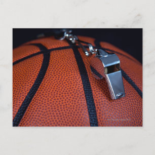 Het fluitje van een scheidsrechter ligt bovenop ee briefkaart