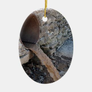 Het vuile water stroomt uit een bruine roestrioolb keramisch ornament