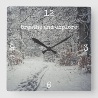 Horloge Carrée Un sentier enneigé à travers une forêt d'hiver