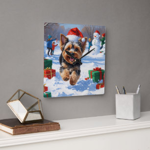 Horloge Carrée Yorkipoo courant dans la neige avec un chapeau de