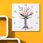 Horloge murale Carré Arbre Arc-en-ciel<br><div class="desc">Cette horloge fantaisiste est décorée d'une impression d'arbre de vie aux couleurs arc-en-ciel. L'arbre a été à l'origine fabriqué en mosaïque à l'aide de minuscules fragments de verre aux couleurs vives. Parce que nous créons notre propre oeuvre, vous ne trouverez pas cette image exacte d'autres designers. Mosaïque originale © Michele...</div>