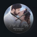 Horloge Ronde Elegant Wedding Photo Chic NewlyWed<br><div class="desc">This elegant script photo clock will be a beautiful keepsake of your wedding day ! Les reads uniques calligraphy reads 'Mr et Mme Alongside your custom family name and date. Add your wedding photo and make this into a perfect vent for the newlywed bride, an anniversary, or vow renewal !...</div>