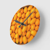 Horloge Ronde Heap of orange kumquats dans cardboard box (Angle)