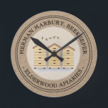 Horloge Ronde Kraft Beekeeper's Shop Clock avec 3 ruches<br><div class="desc">Fait un beau cadeau pour votre apiculteur préféré. Parfait pour être accroché à votre atelier derrière votre table Farmer’s Market.</div>