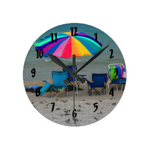 Horloge Ronde le parapluie de plage coloré préside la scène d