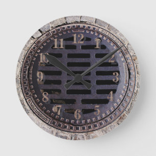 Horloge Ronde Manhole cover and cobblestone road clock